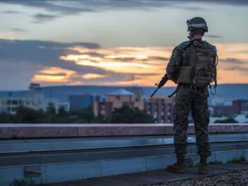 Marine Corps Embassy Security Guard on a rooftop looking out over cityscape. Photo from mcesg.marines.mil